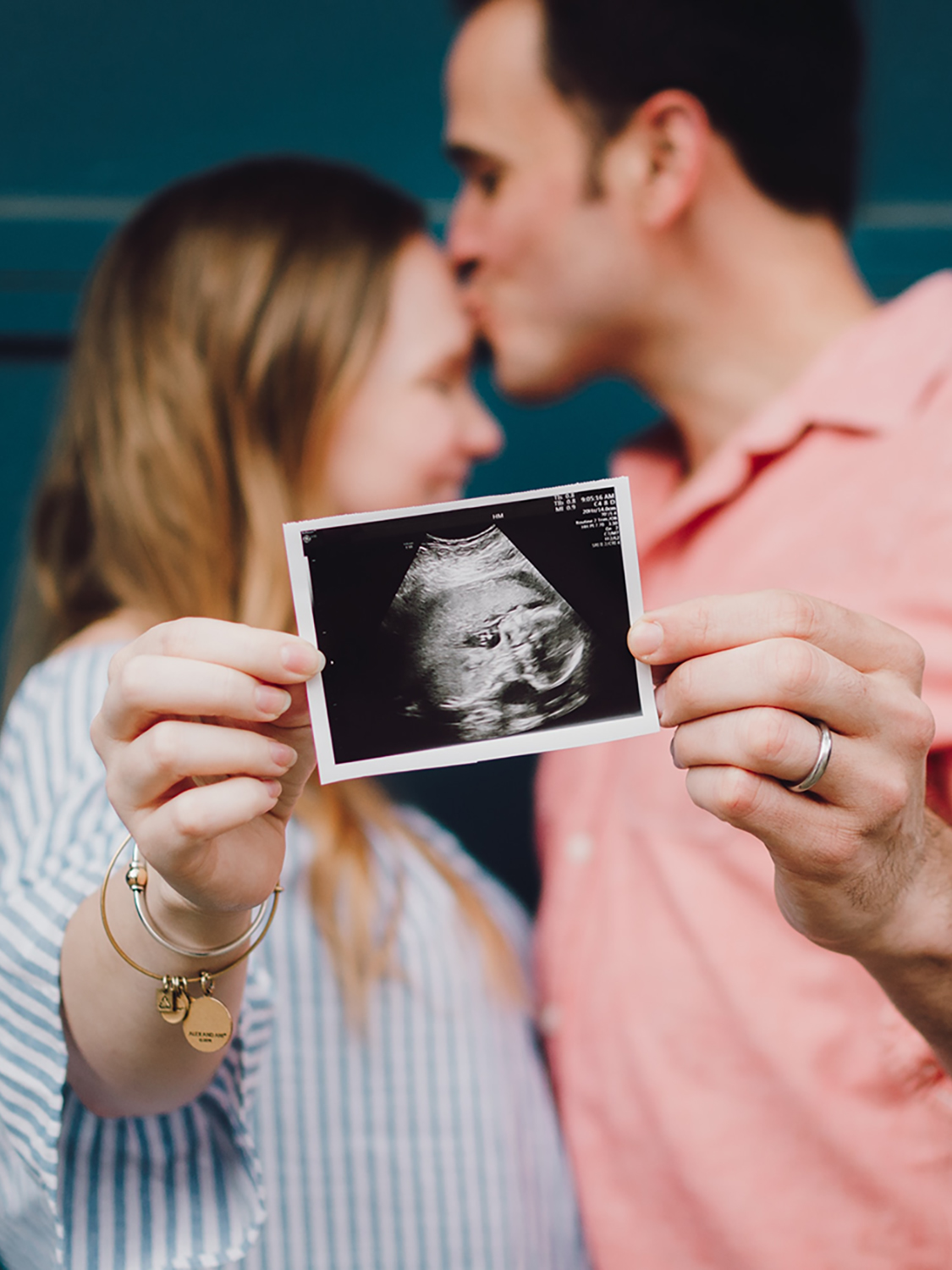 Happy couple holding up a ultrasound scan of a baby